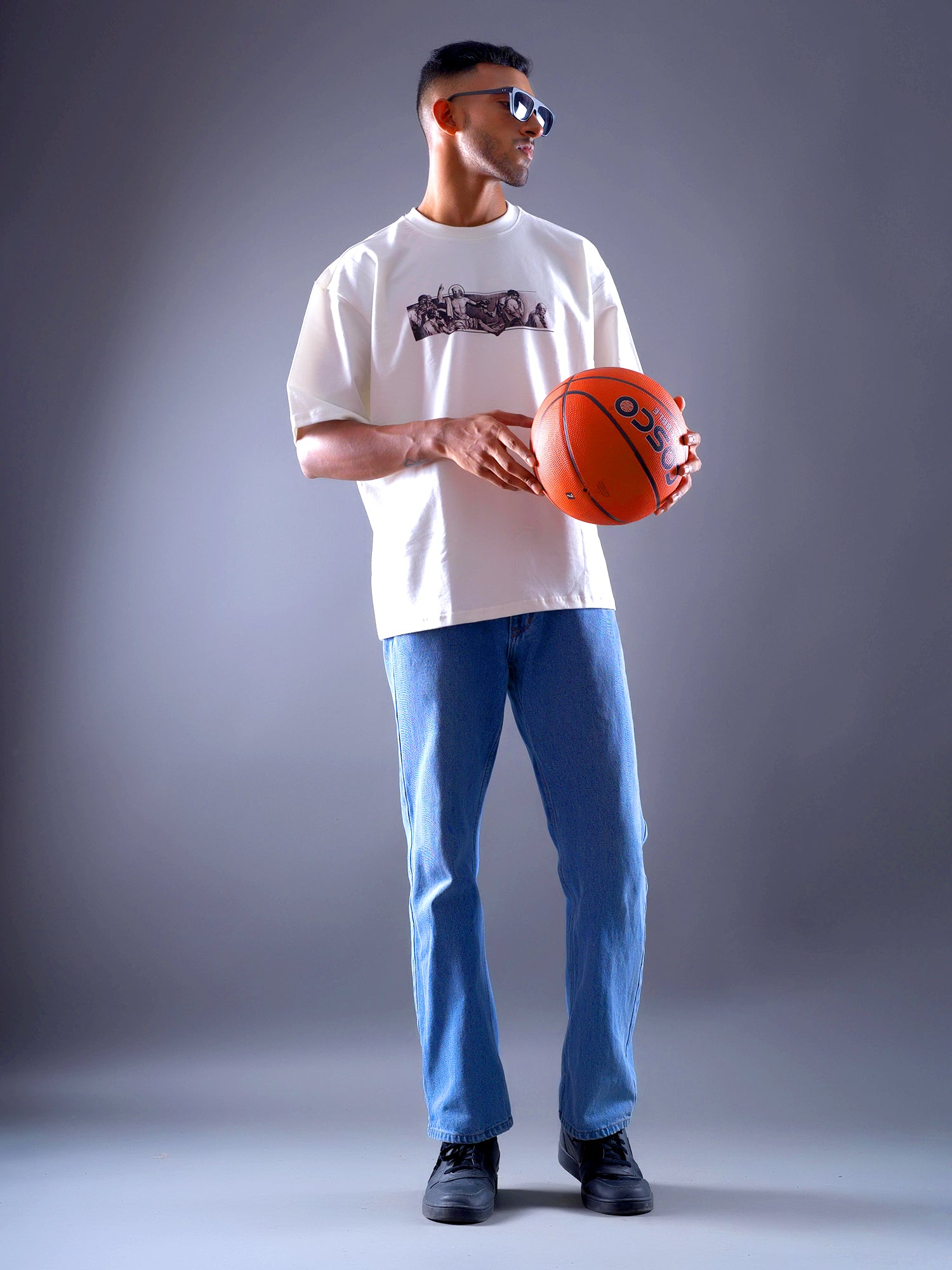 Man holding a basketball against a gray background