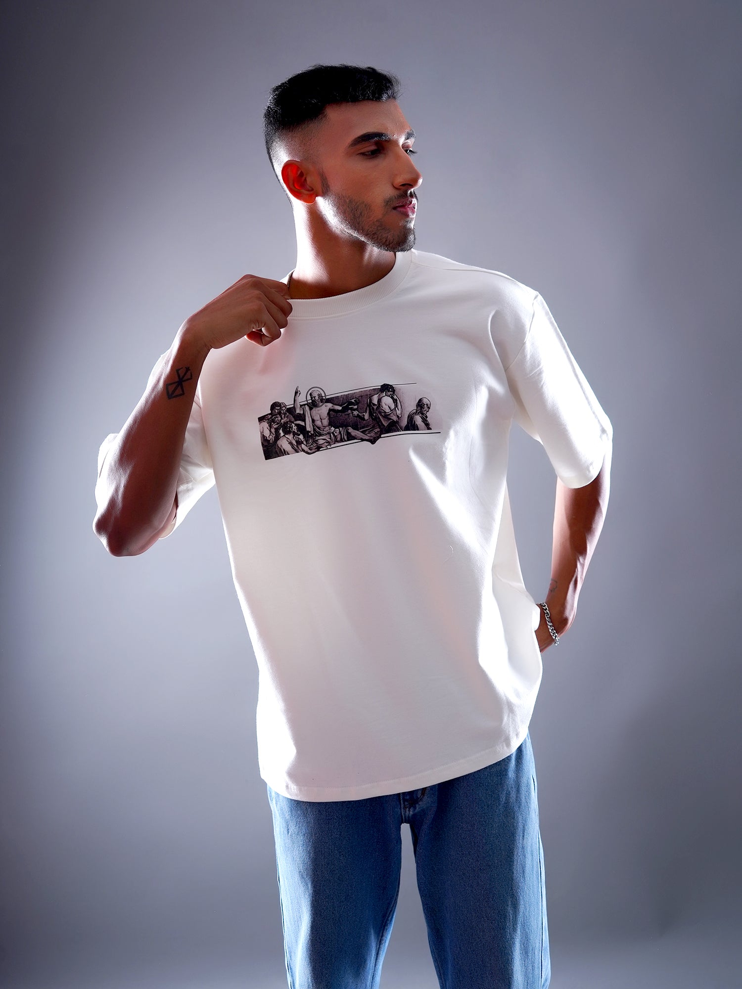 Man wearing a white t-shirt with a graphic design on a gray background