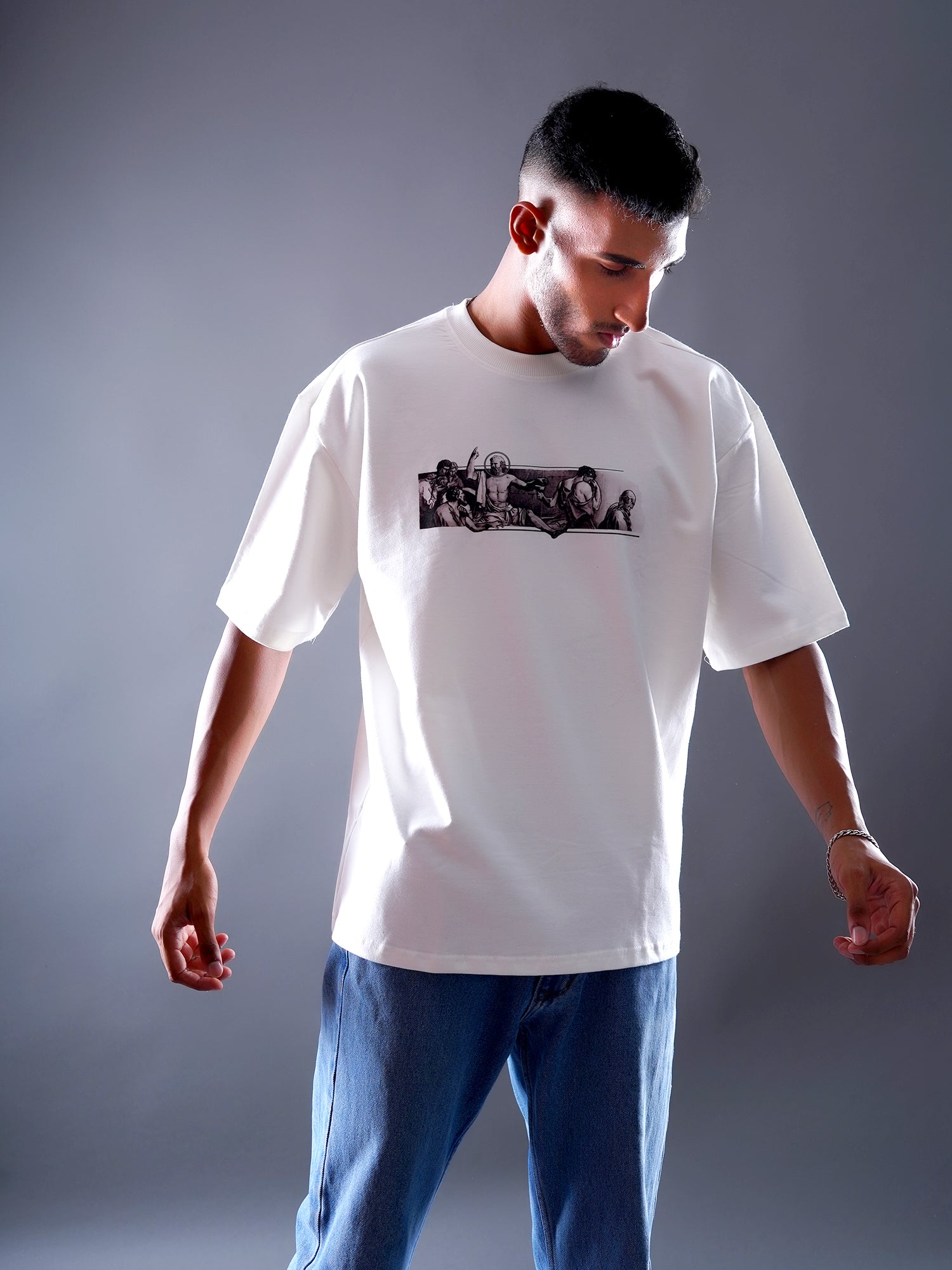 Person wearing a white t-shirt with a graphic design on a gray background