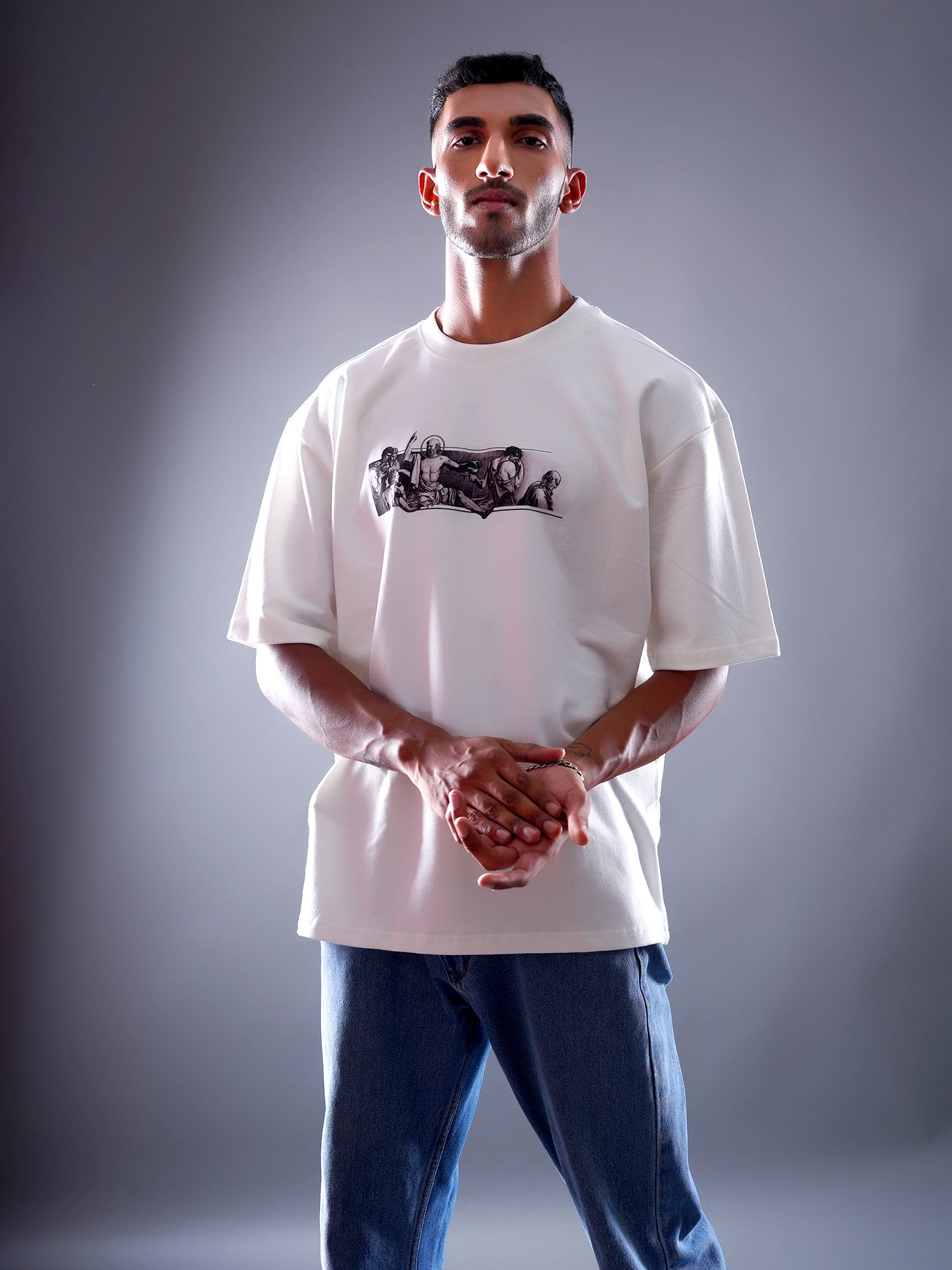 Man wearing a white t-shirt with a graphic design on a gray background
