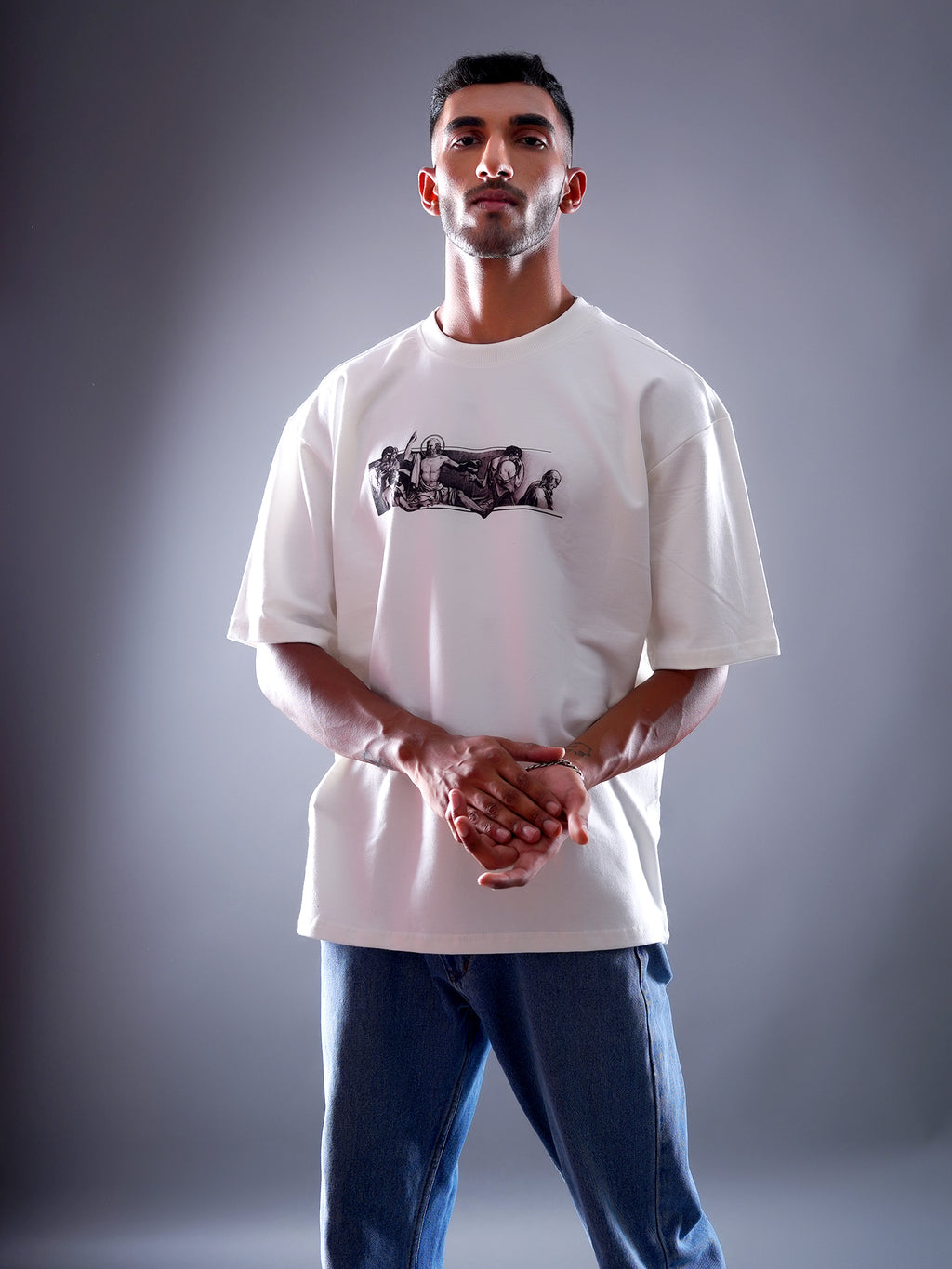 Man wearing a white t-shirt with a graphic design on a gray background